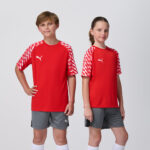 Two youth models in matching red Puma soccer jerseys and grey shorts