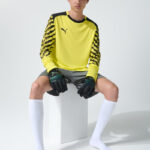 Male model in yellow goalkeeper kit, seated