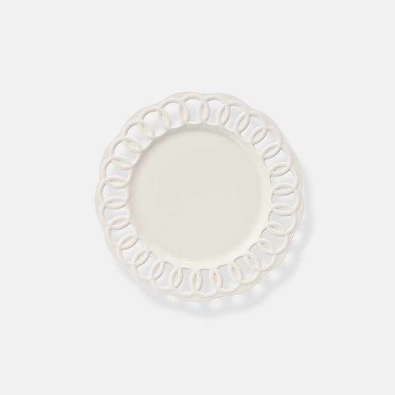 Product photography of a white ceramic dinner plate with an open lattice rim, shot from above on white
