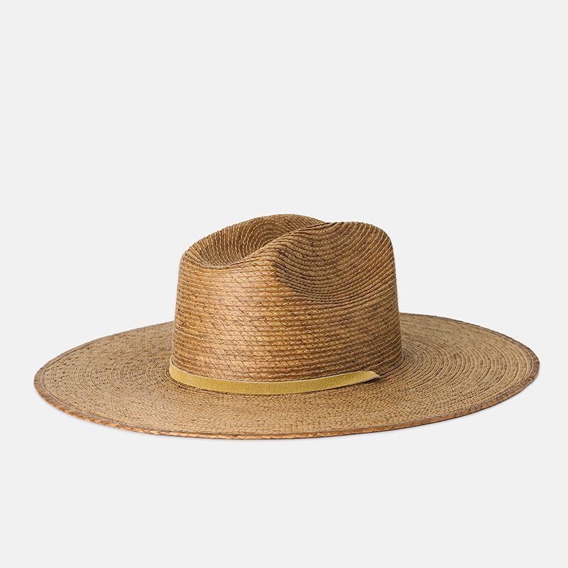 Product photography of a palm straw fedora sun hat with a mustard band, three-quarter view showing the crown crease
