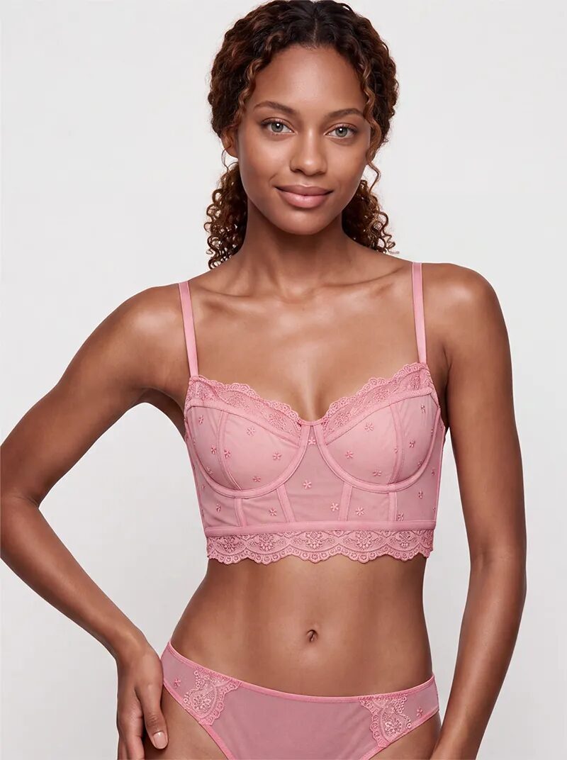 AI-generated model wearing a rose pink embroidered mesh bustier and matching briefs, front view on a light grey background