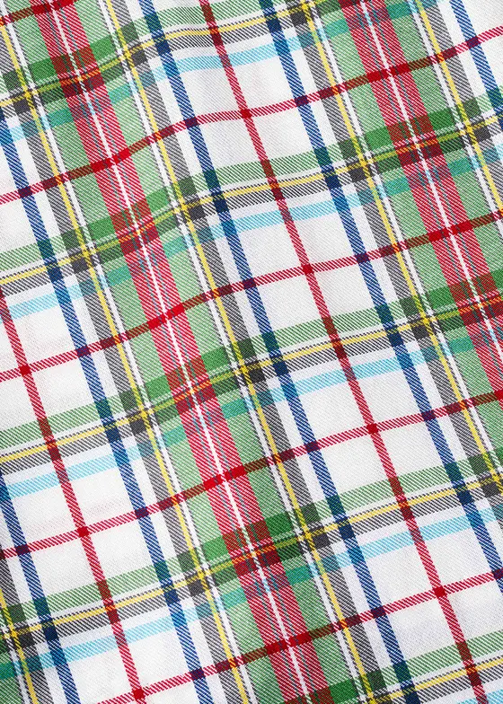 Fabric swatch close-up of a red, green and yellow tartan plaid cotton on a white ground