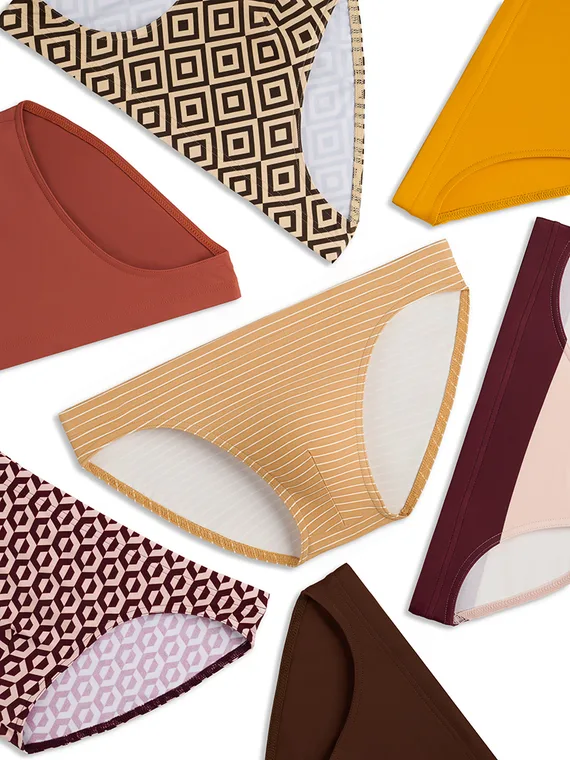 Styled flat lay of nine men's briefs in prints and solid colours arranged on white