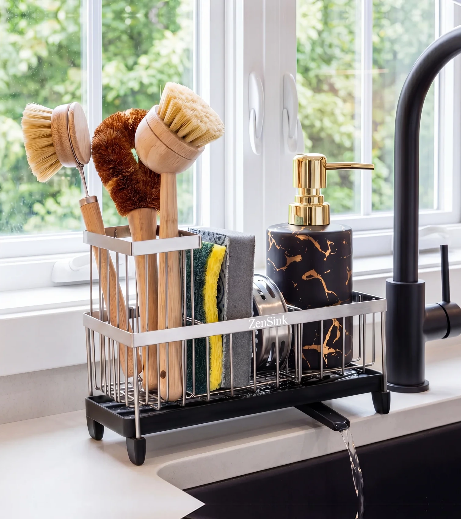 Amazon lifestyle image of a sink caddy with brushes, sponges and a soap dispenser by a kitchen window