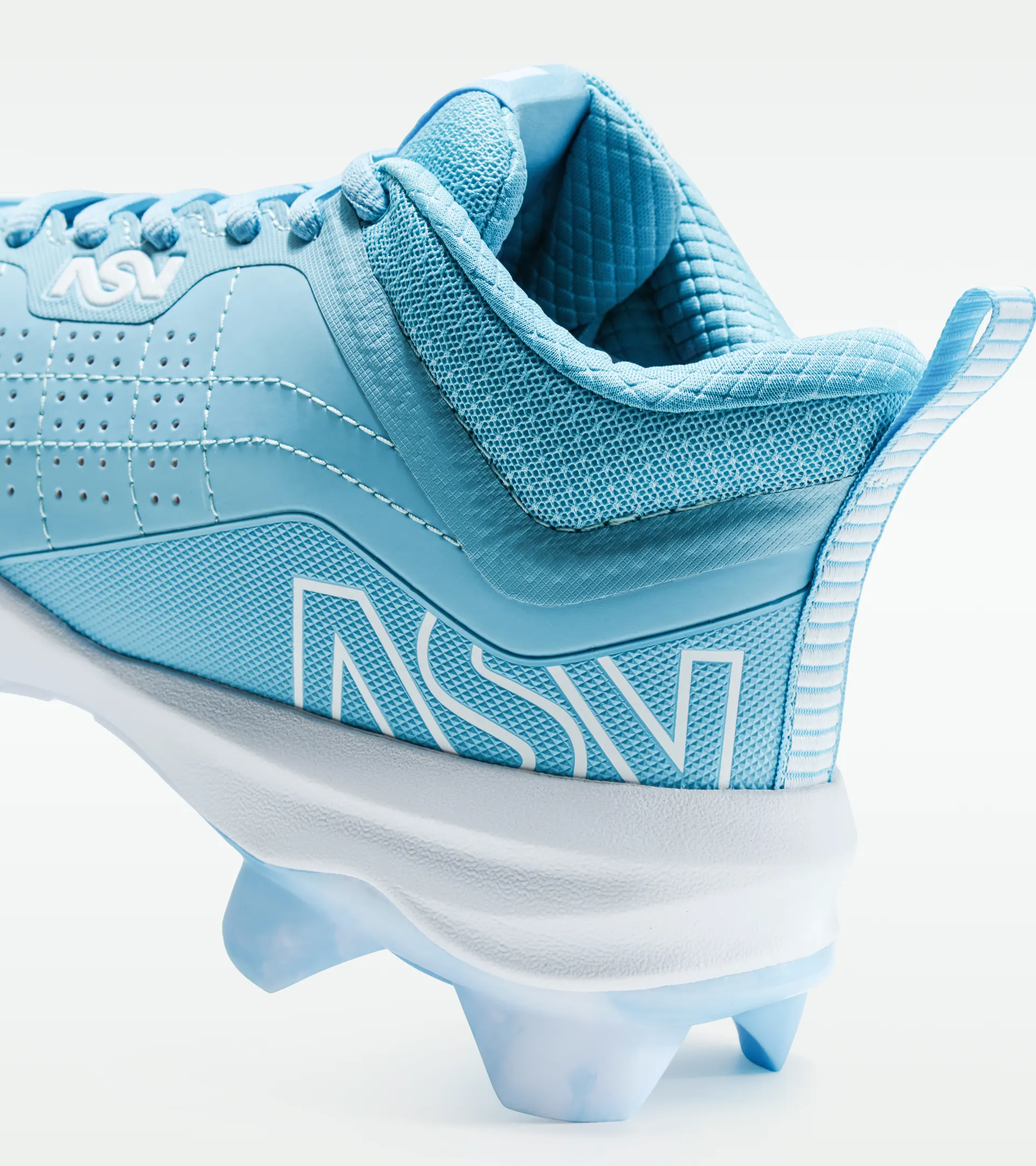 Close-up shoe photography of a light blue cleat showing the heel, mesh collar and logo detail