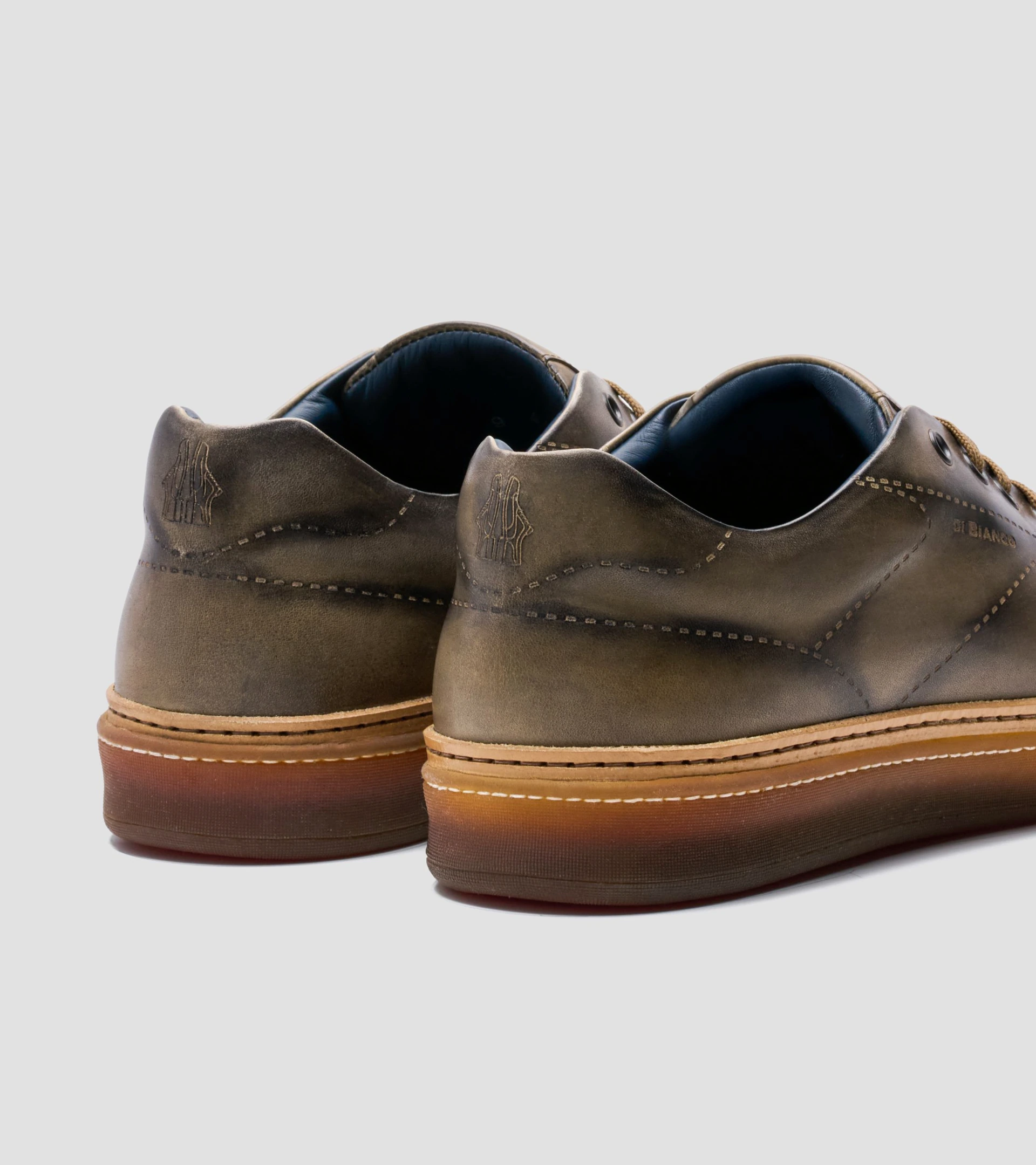 Close-up shoe photography of olive hand-finished leather sneakers, heel view