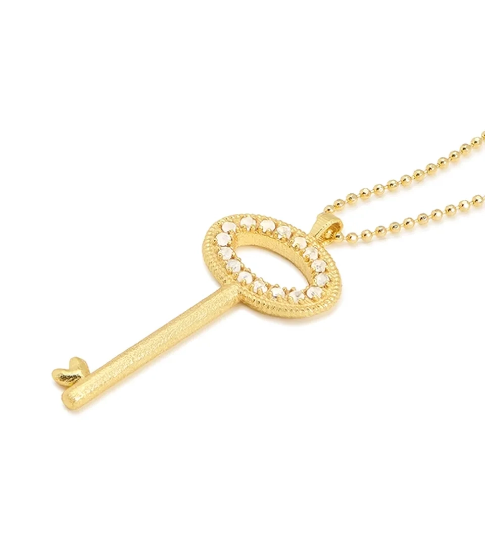 Jewelry photography of a gold key pendant necklace with crystals