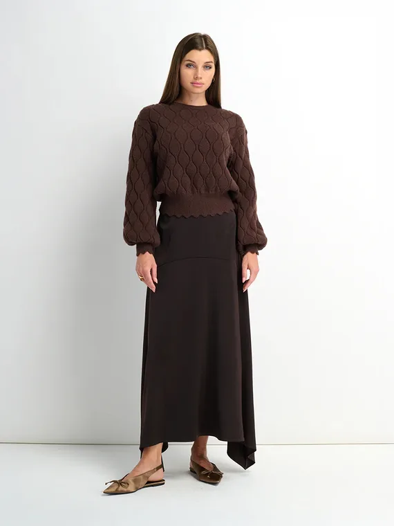 Model in a brown textured knit sweater with a long brown skirt