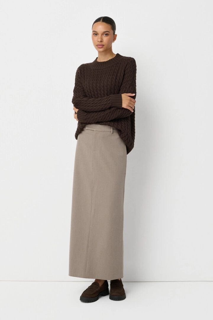 On-model photography of a brown cable-knit sweater and taupe maxi skirt