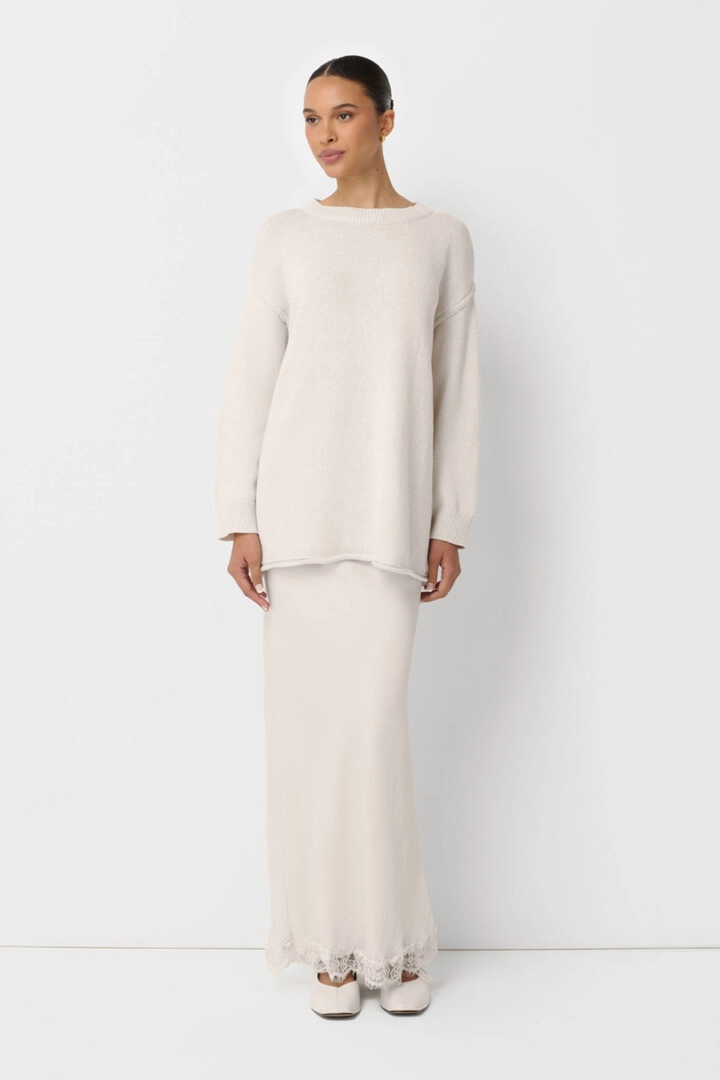 On-model photography of a cream knit top and maxi skirt