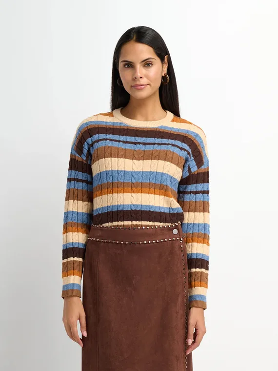 Model in a striped cable knit sweater with a studded brown suede wrap skirt