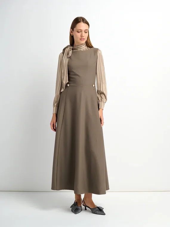 Second angle of the taupe dress and scarf-tie blouse look, showing the skirt line