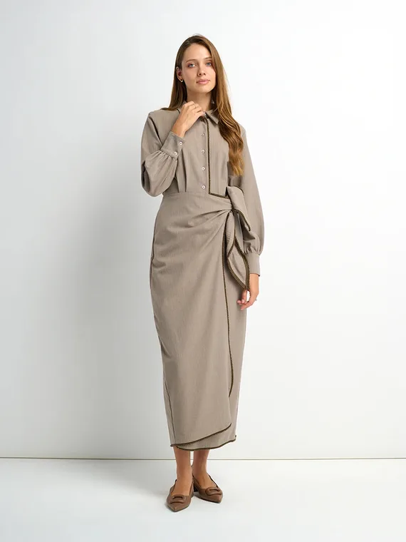 Model in a taupe shirtdress with a tie-wrap skirt, full-length studio shot