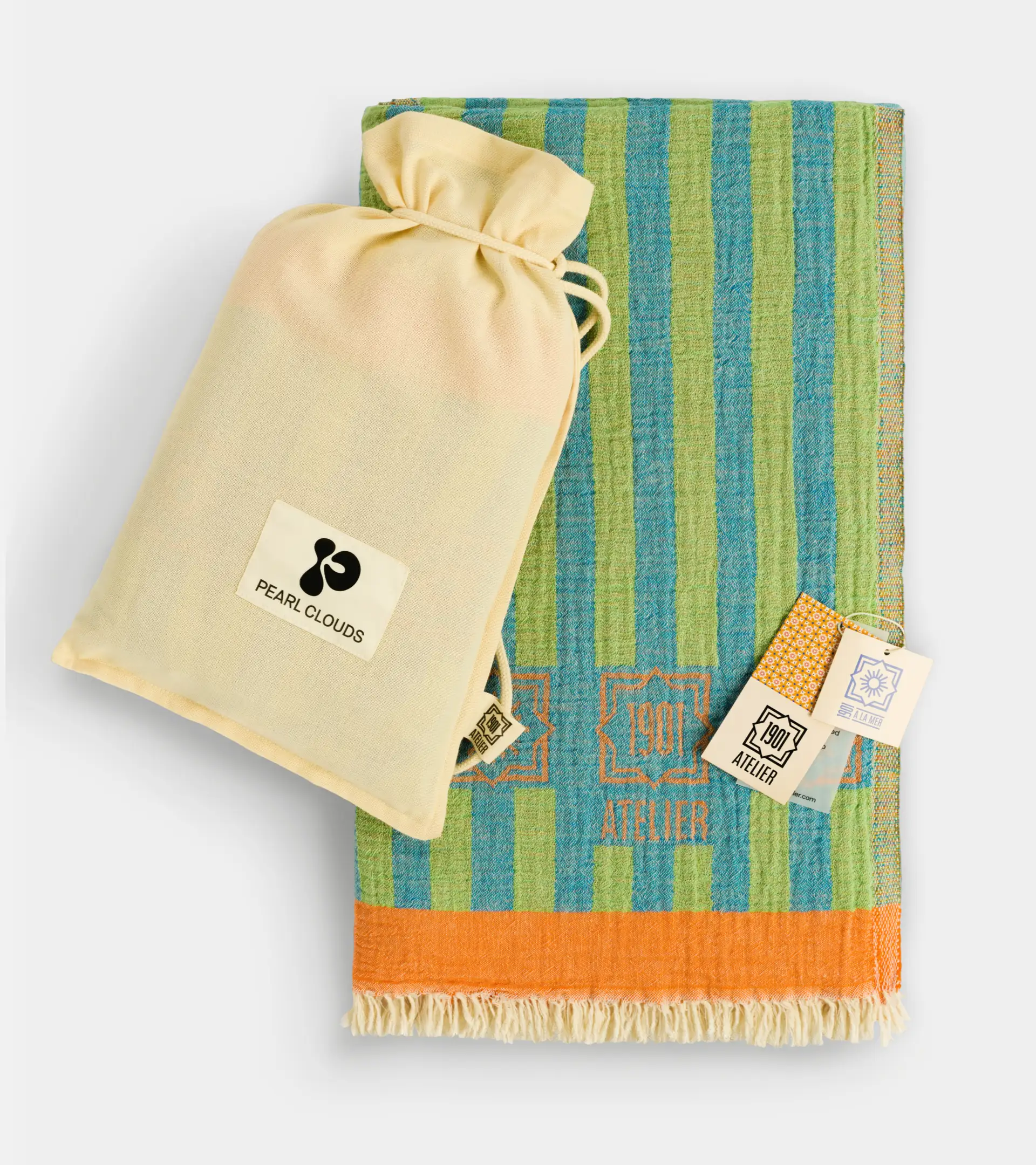 Product photography of a striped cotton beach towel with a drawstring gift pouch