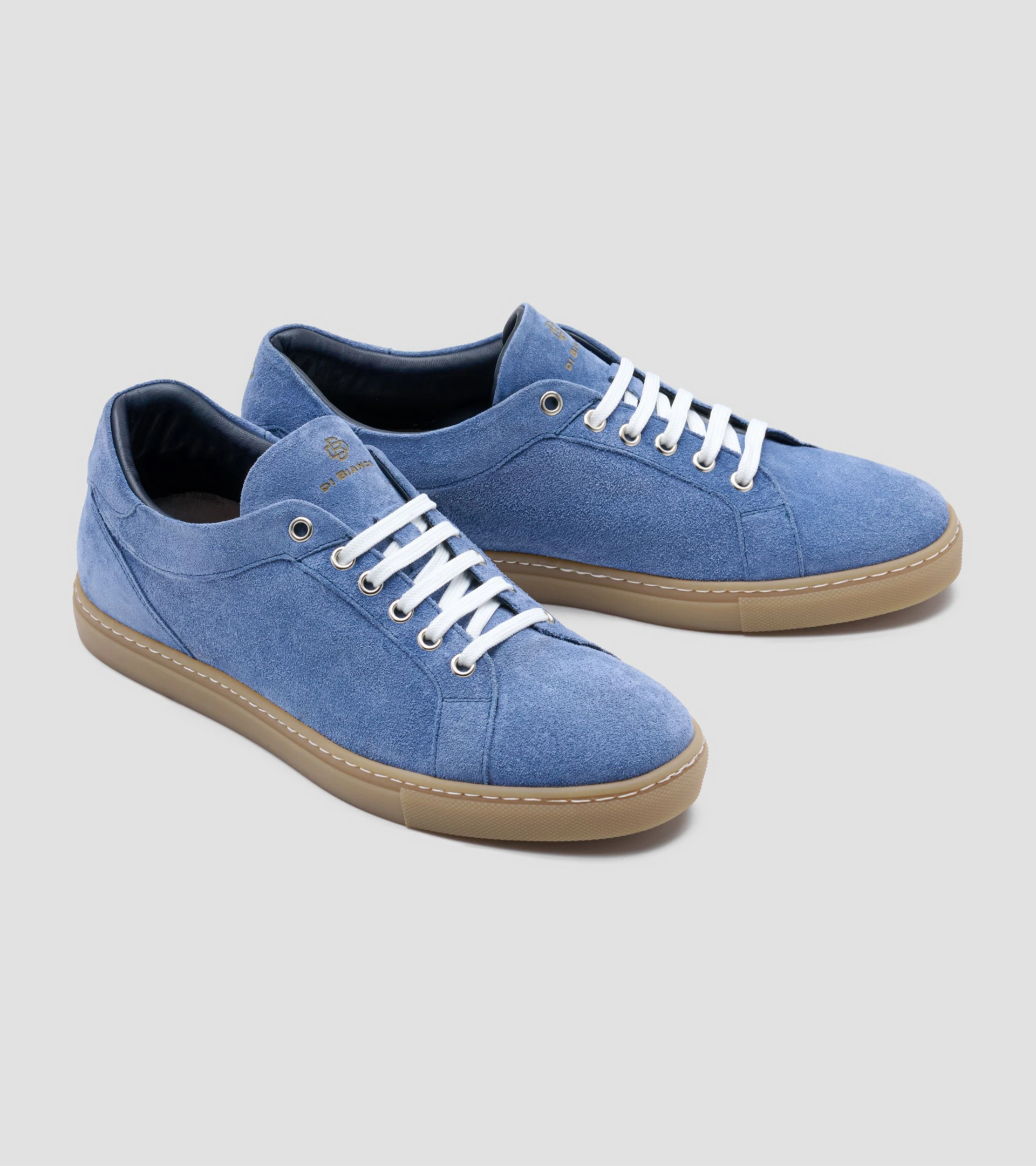 Shoe photography of a pair of blue suede sneakers with gum soles