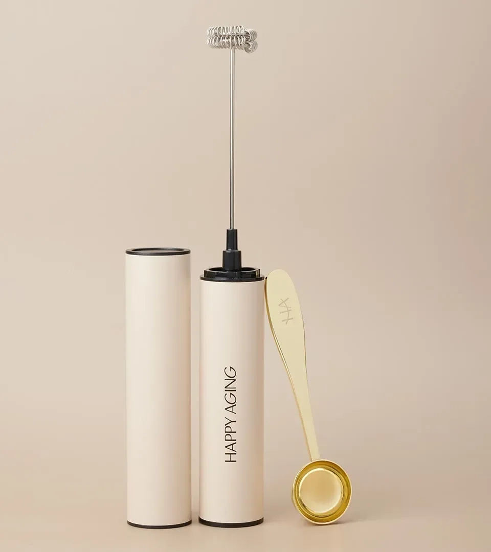 Wellness product photography of a frother, case and gold measuring scoop