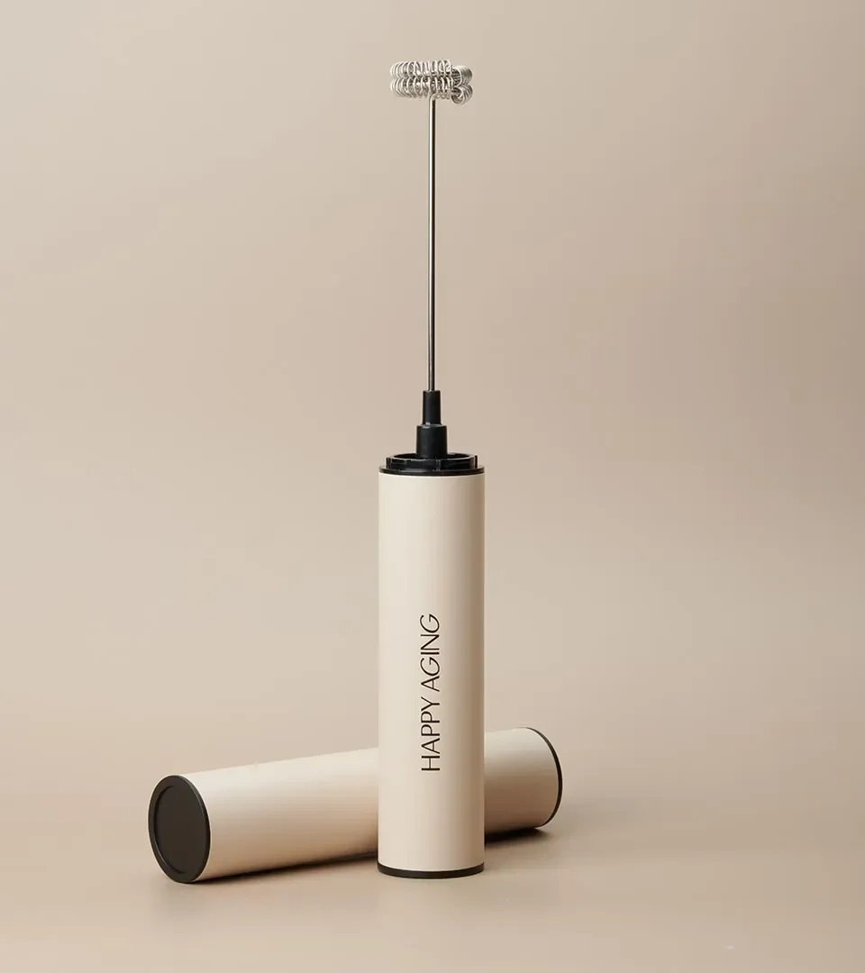 Wellness product photography of a Happy Aging handheld frother with its case