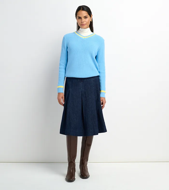 On-model photography of a light blue v-neck sweater with denim midi skirt and brown boots