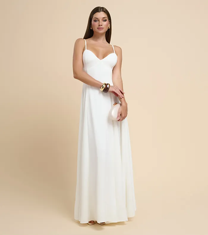 On-model photography of a white slip evening gown with thin straps, styled with a small clutch