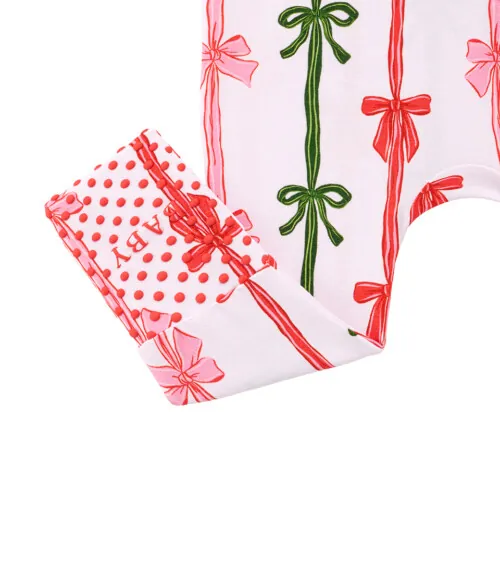 Detail flat lay photography of folded bow-print baby pants showing cuff and dotted lining