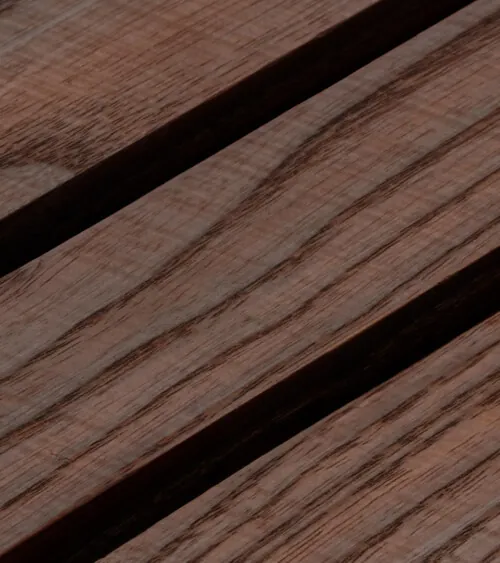 Close-up detail of dark walnut wood slat panel grain and grooves, detail product photography