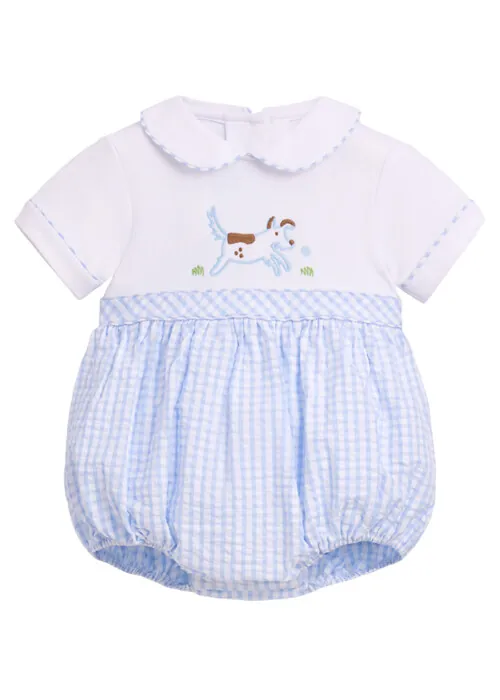 Flat lay photography of a baby romper with embroidered dog detail for children's apparel photography.