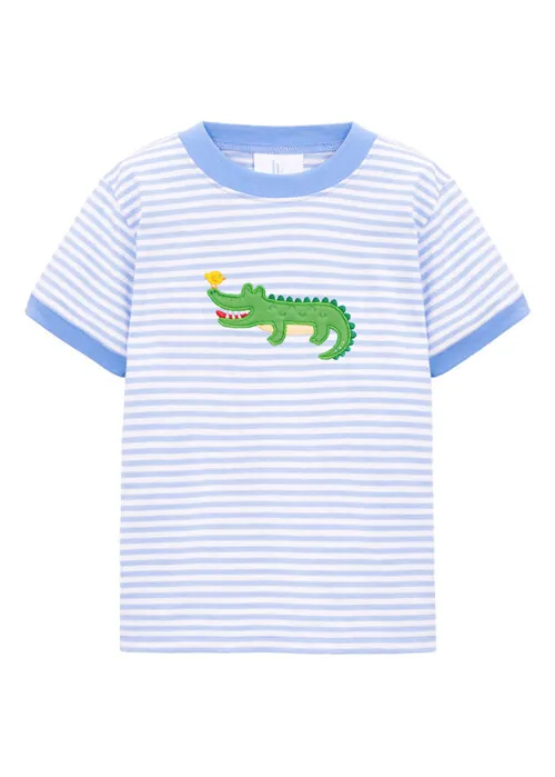 Flat lay photography of a striped children's graphic T-shirt with embroidered alligator detail.