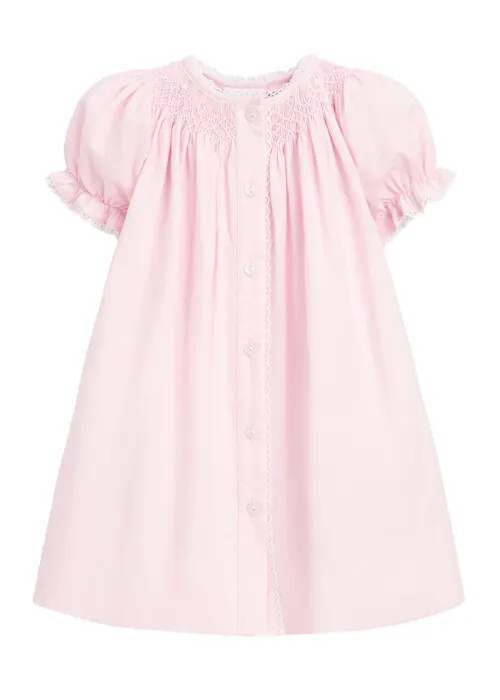 Flat lay photography of a pink girls dress with embroidered details for e-commerce apparel photography.