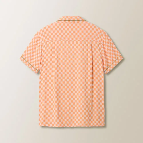 Flat lay photography showing the back view of an orange checkered short-sleeve shirt for online retail apparel photography.