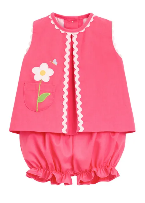 Flat lay photography of a pink girls two-piece outfit with floral applique detail for e-commerce clothing photography.