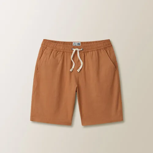 Flat lay photography of tan men's drawstring shorts on a neutral background for online retail photography.