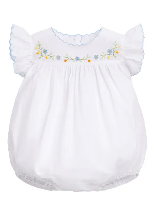 Flat lay photography of a white embroidered baby romper photographed for children's apparel product photography.
