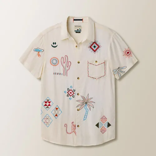 Flat lay photography of a white embroidered short-sleeve button-down shirt for e-commerce clothing photography.