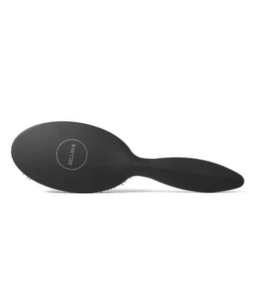 Black oval paddle hairbrush photographed on gray background, beauty product photography