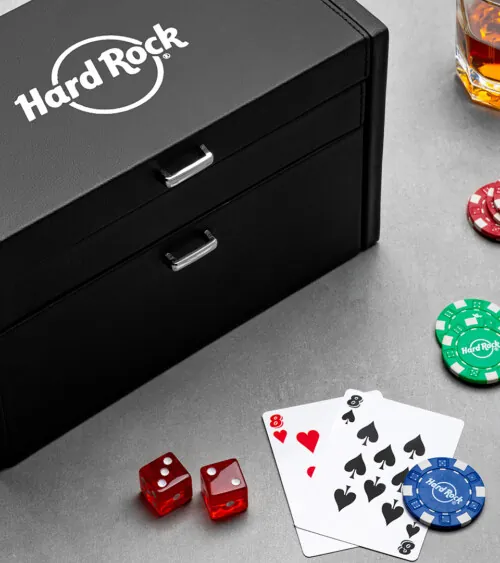 Black leather game box with playing cards, dice, and poker chips styled on a gray surface, lifestyle product photography