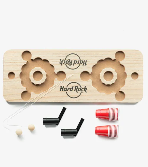 Wooden mini party game set with red cups and launchers arranged on white background, studio product photography