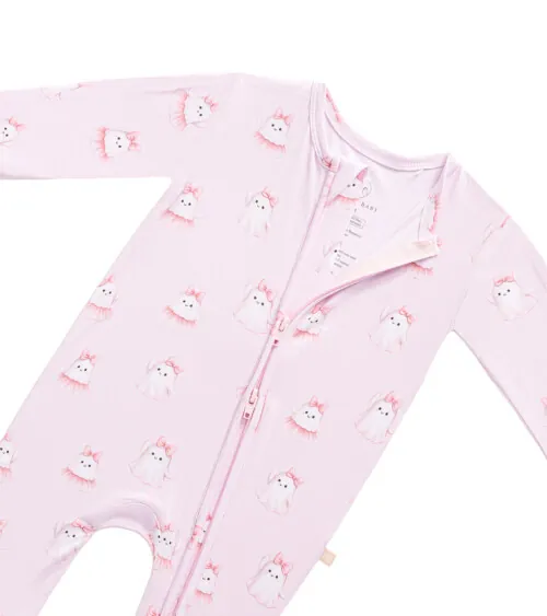 Flat lay detail photography showcasing zipper construction and printed fabric details on a baby sleeper.