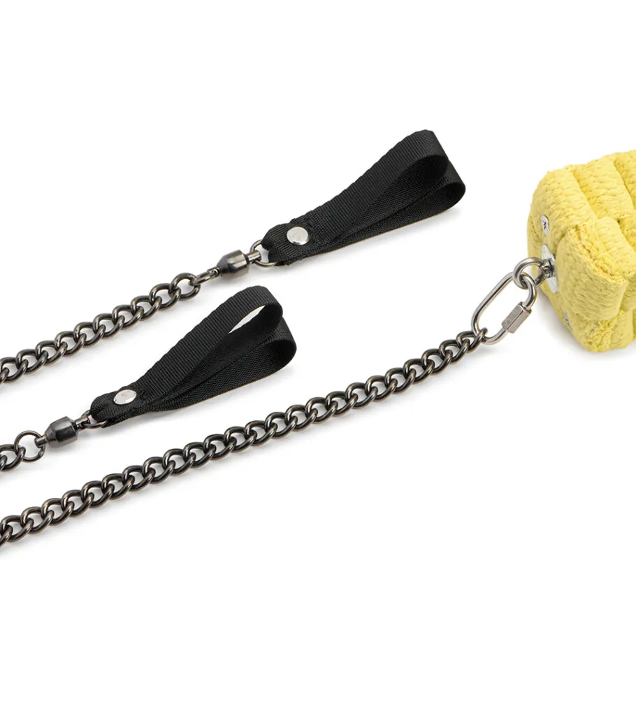 Close-up product photography of a chain with black tassel clips and a yellow woven charm