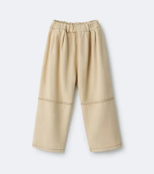 Flat lay photography of beige children's pants photographed for apparel product photography.