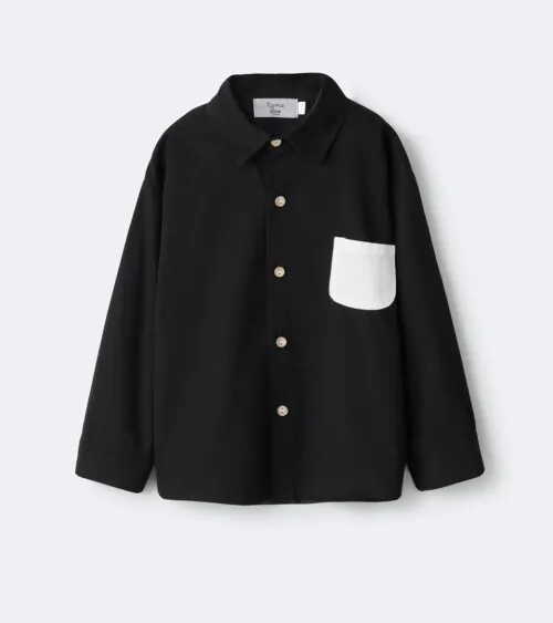 Flat lay photography of a black children's button-down shirt with contrast pocket for e-commerce apparel photography.