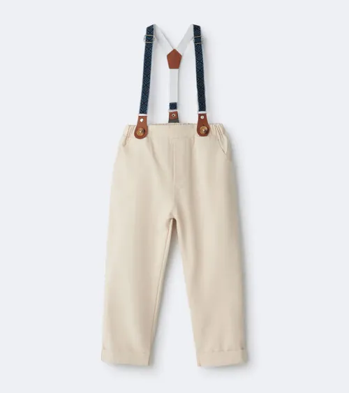 Flat lay photography of a formal children's outfit featuring suspenders, dress shirt, and trousers photographed for e-commerce apparel photography.