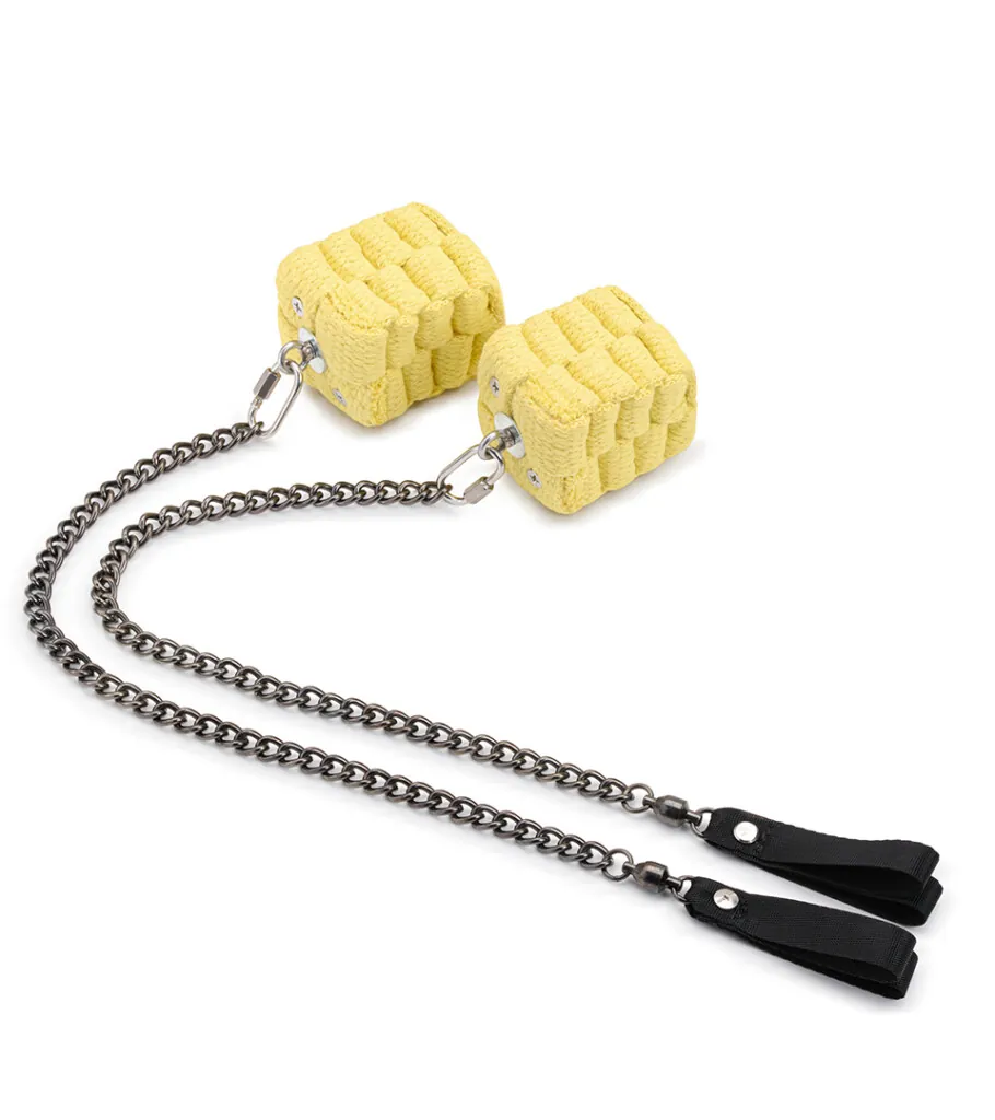Product photography of two yellow textured charms on chains ending in black clips