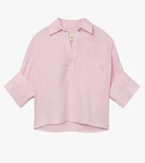 Flat lay photography of a pink popover blouse with rolled cuffs