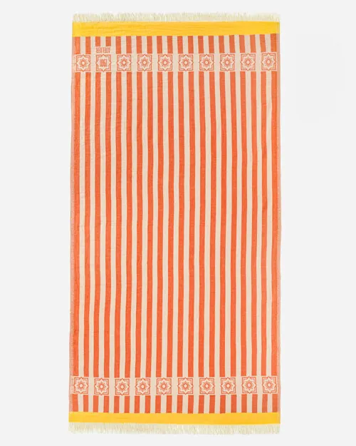 Flat lay photography of a orange and cream striped towel with a teal border band, shown full length