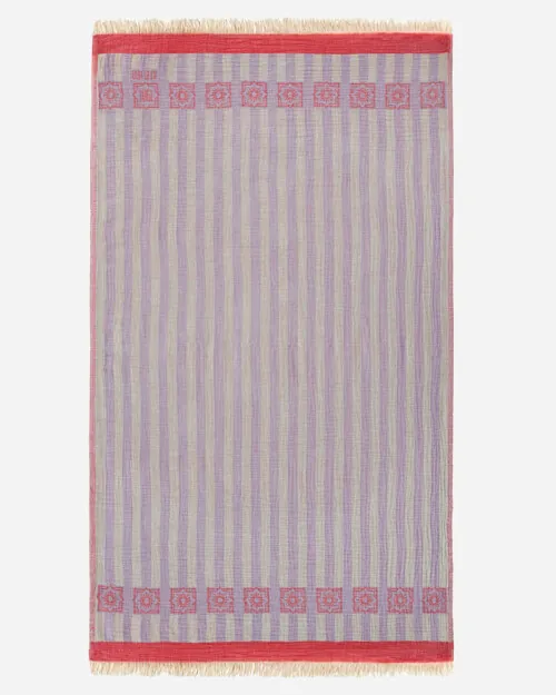 Flat lay photography of a lavender and grey striped towel with a red border band, shown full length