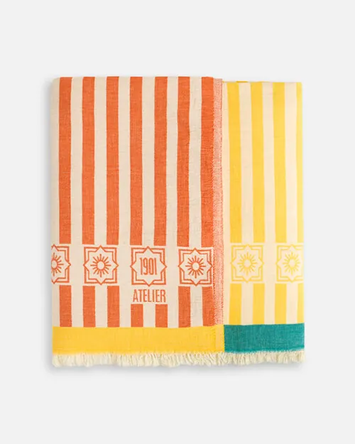 Product photography of a coral striped towel and a yellow striped towel folded together as a pair