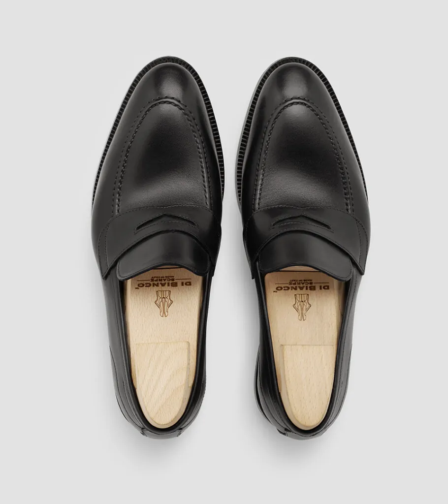 Shoe product photography of a pair of black leather loafers shot from directly overhead showing the cream linings