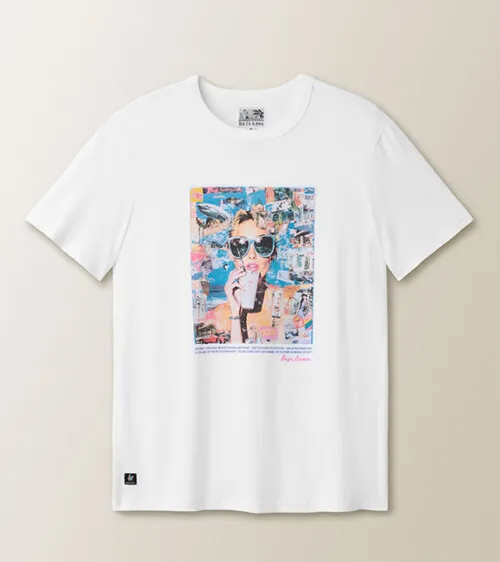 Flat lay clothing photography of a white graphic T-shirt with a photo-collage print, on a beige background.