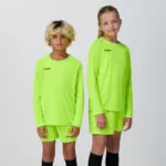Two youth models in matching neon yellow-green long sleeve soccer jerseys