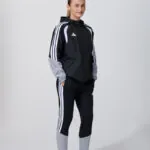 Female model in black adidas track jacket and leggings